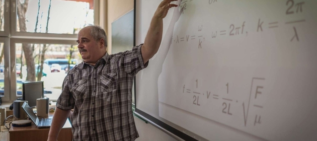 Wykładowca pokazuje obliczenia na tablicy/The lecturer shows the calculations on the blackboard